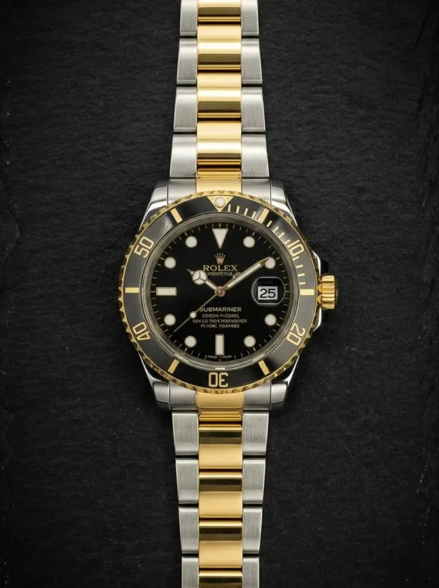 Two-tone gold and silver watch with black dial on a dark background