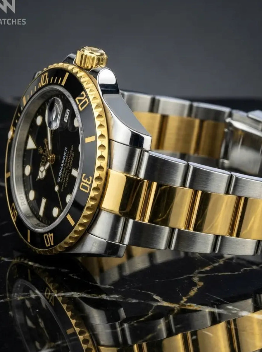 Gold and silver watch on a reflective black stone surface with Willi Watches logo.